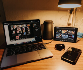 laptop, celular, tablet y parlante sobre un escritorio