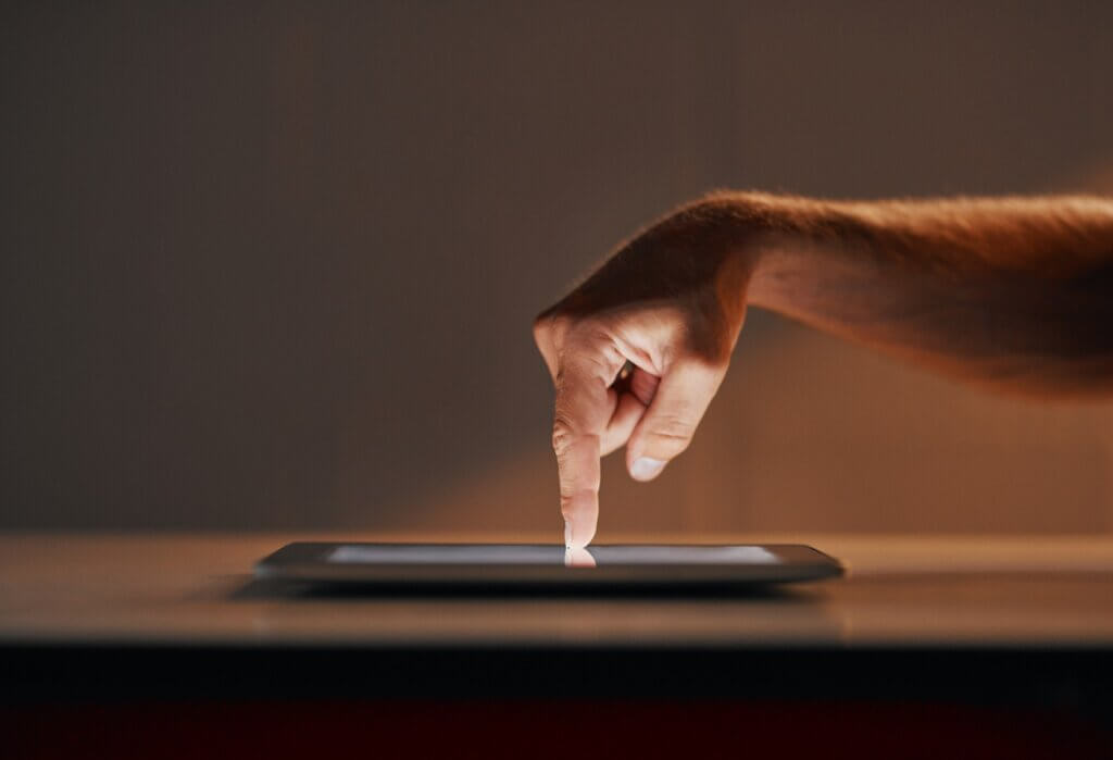 a finger pointing down on a tablet.